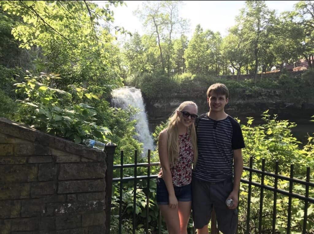 Standing near Minnehaha Falls, which drops over a large cliff.