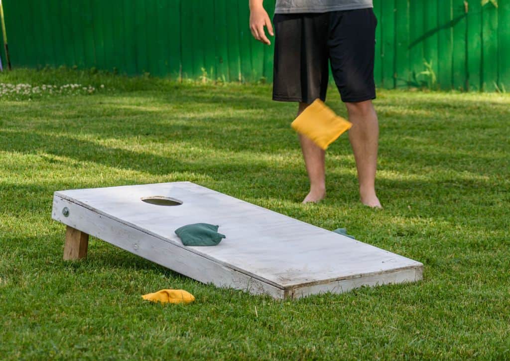 Playing lawn games like cornhole with friends is a fun activity.