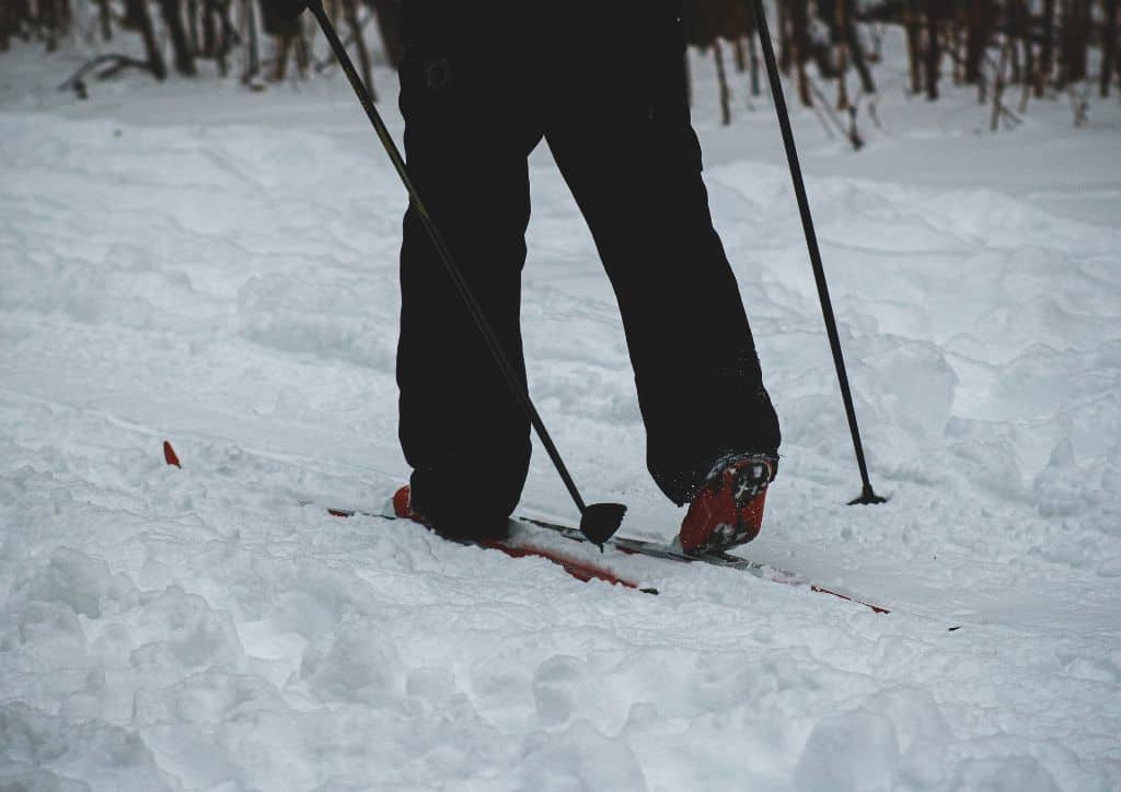 A person cross country skiing down a snow-covered trail.