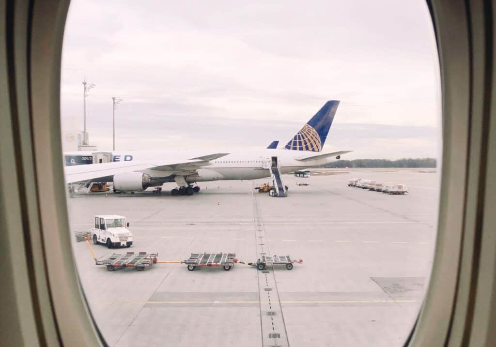 A plane sitting on the runway, as seen from outside a plane window.