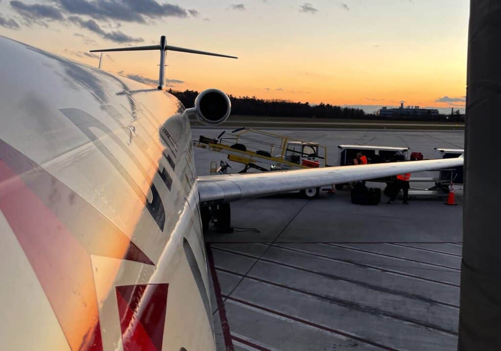 A view of a Delta plane on the runway at sunset.