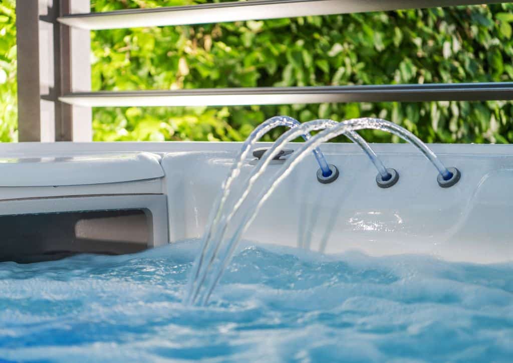 Water spouting from a jet into an indoor hot tub.