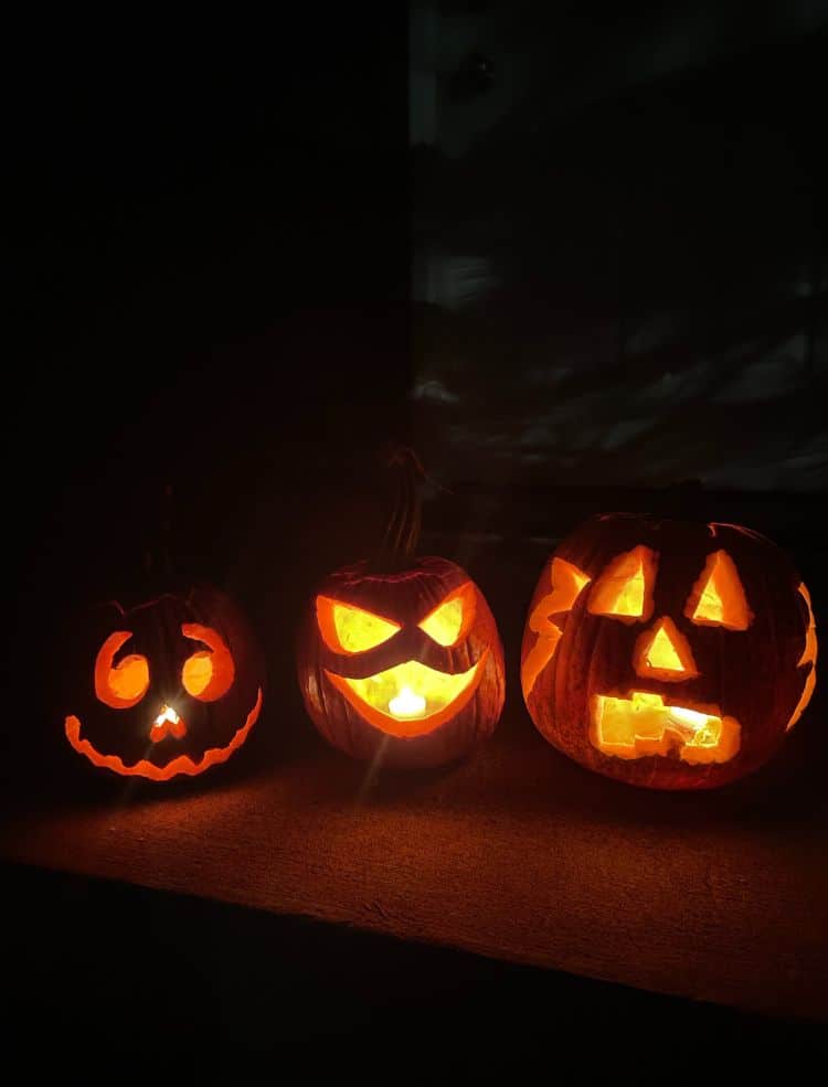 Three pumpkins on a step in Minneapolis in the fall.