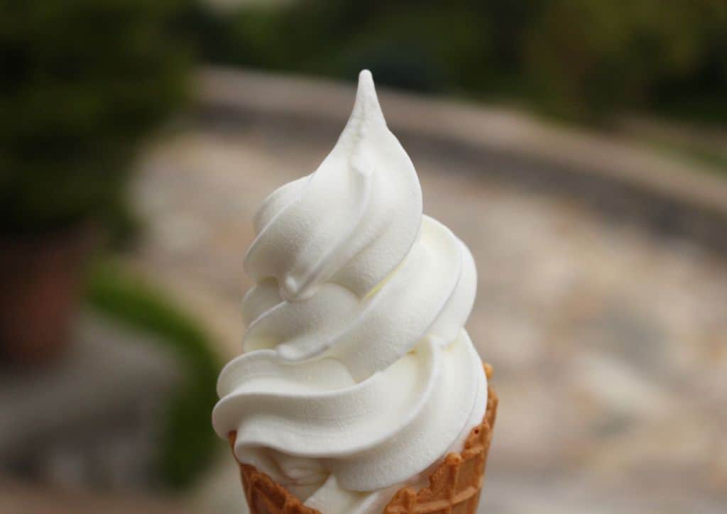 A vanilla soft serve ice cream cone.