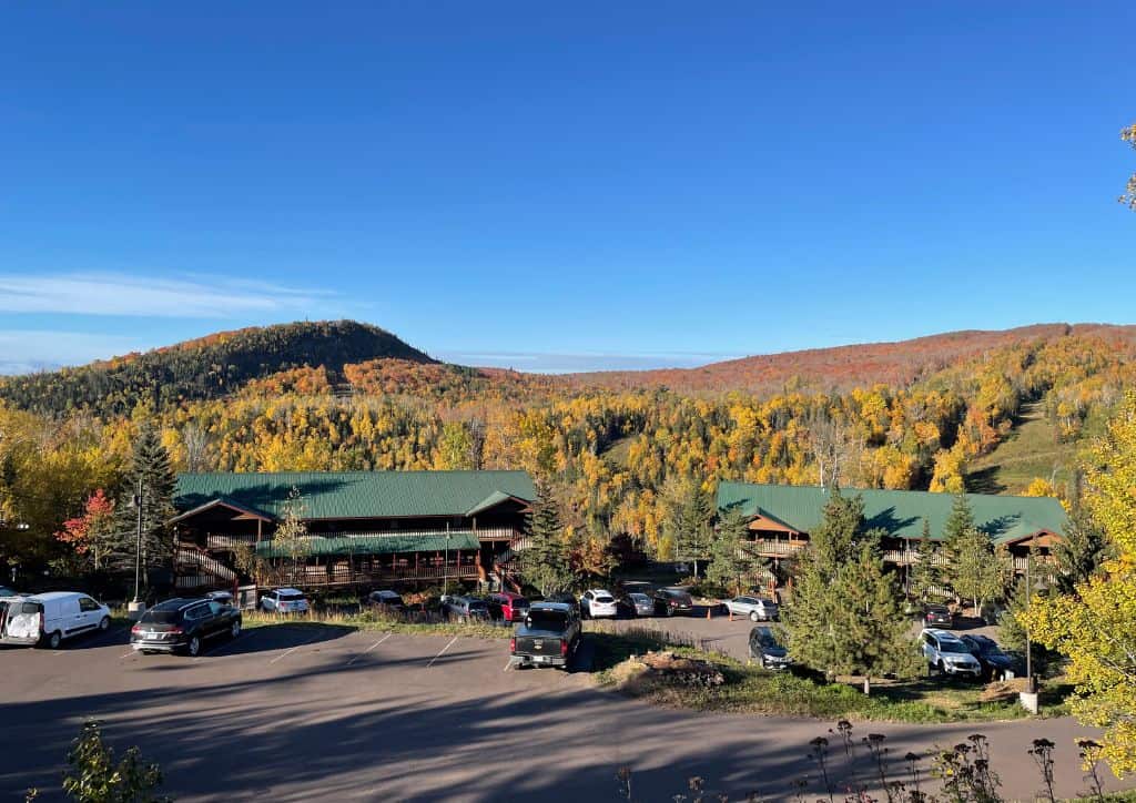 Two hotels as seen from Lutsen Mountain with fall foliage in the background.