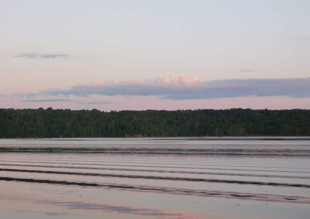 A view of a lake at sunset from a Minnesota camper cabin.