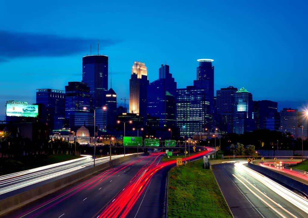 The skyline of Minneapolis at night from above an interstate.