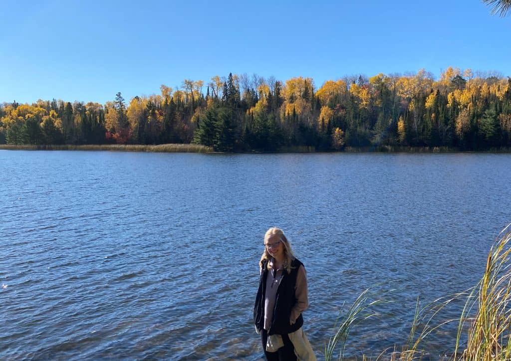 Myself standing by a lake on a hike in the Twin Cities.