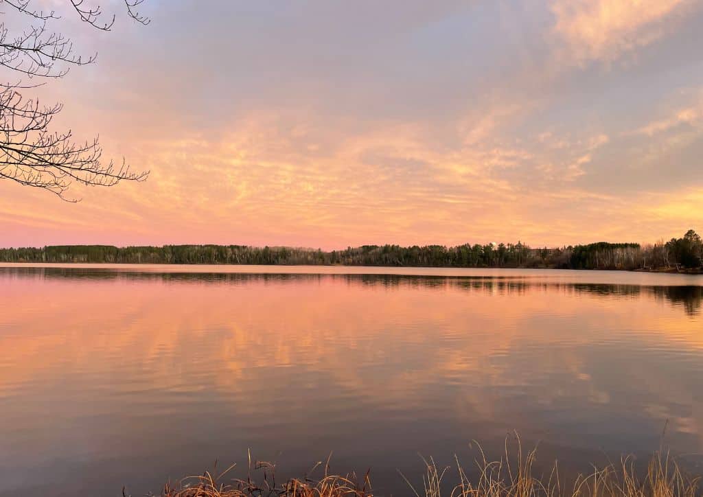 A lake at sunset from the shore of a dog friendly beach in Minneapolis.