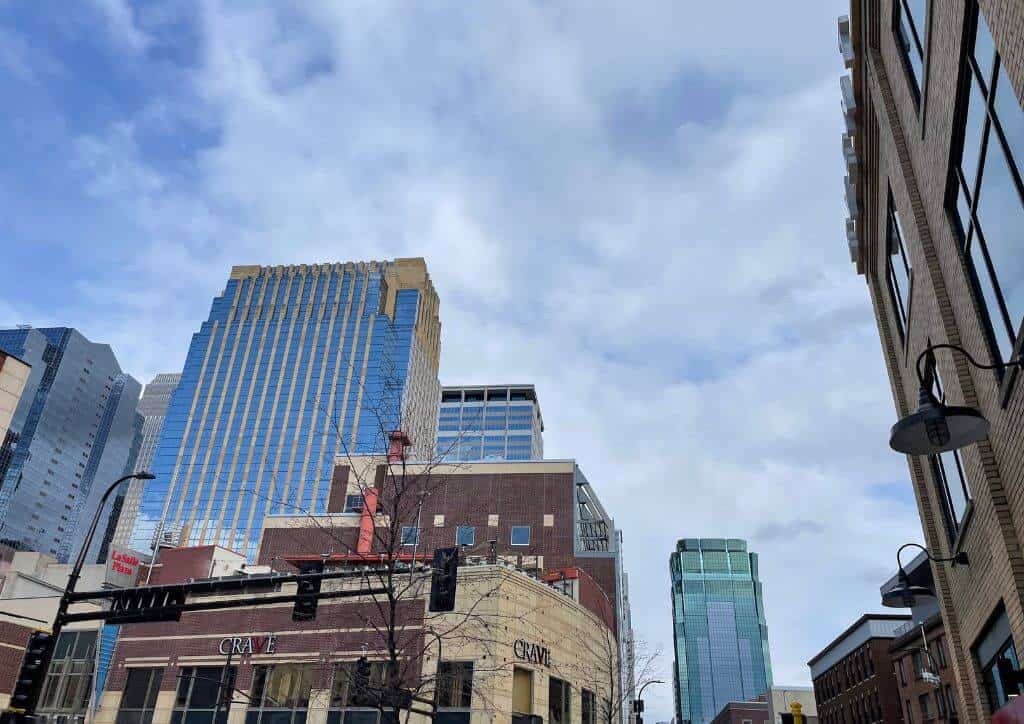 A look up at skyscrapers with a blue sky above them.
