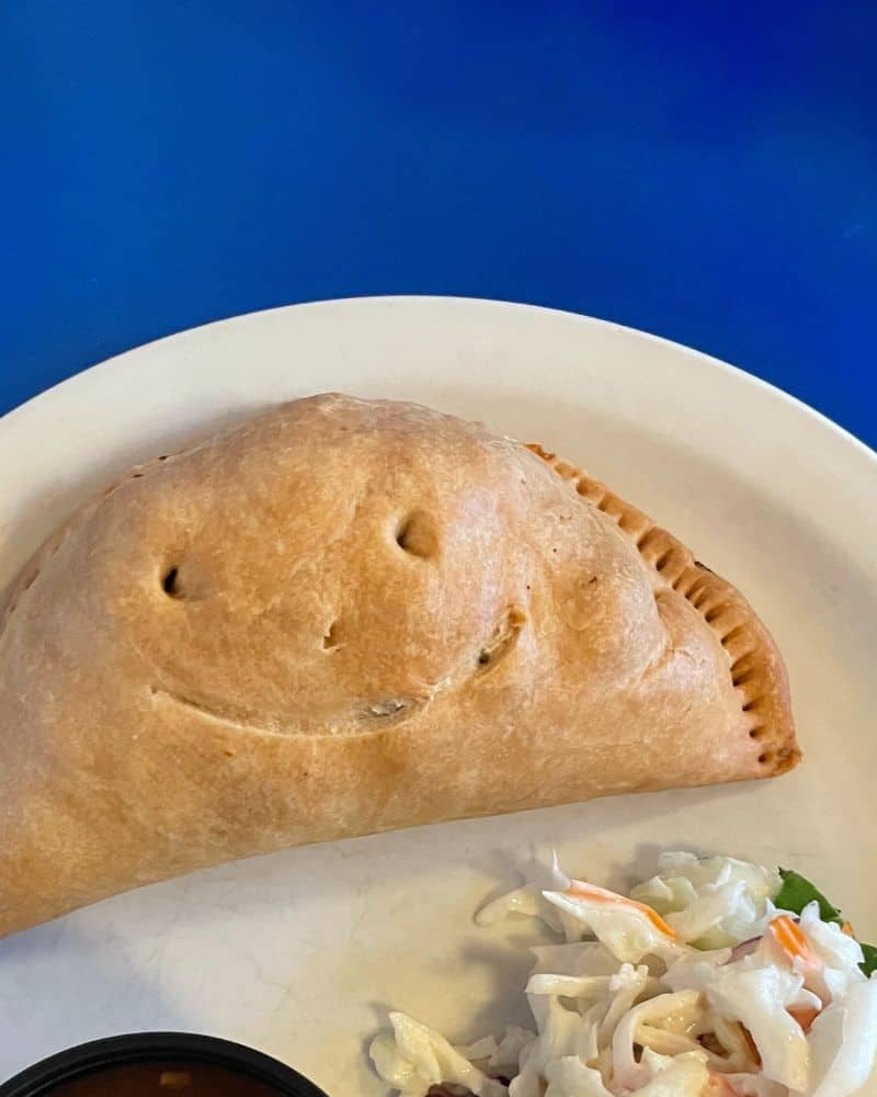 A pasty on a plate with a smiley face on it.