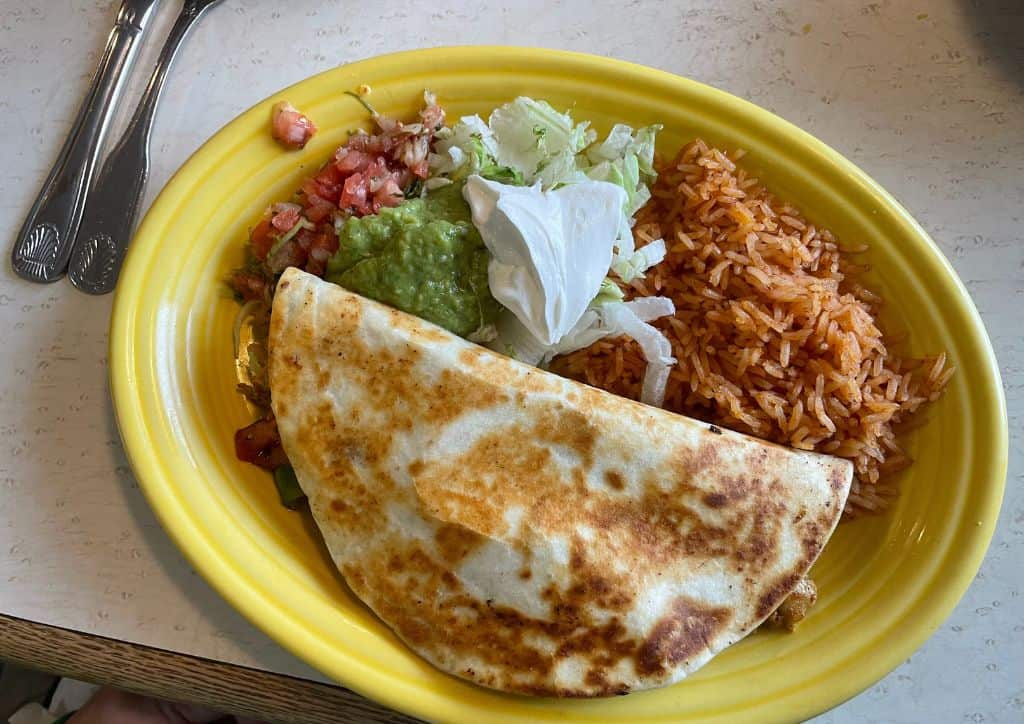 A plate with an enchilada, rice, and fixings at a Mexican restaurant in Duluth, MN.