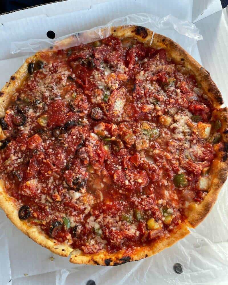 A large deep dish pizza that was ordered at a Chicago restaurant.