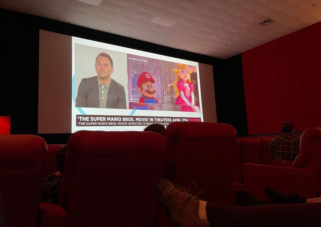 A movie playing on a screen at a large movie theater.